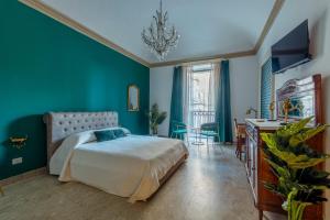 ein Schlafzimmer mit einem Bett und einer grünen Wand in der Unterkunft Baroque in Acireale
