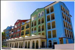 un edificio colorato con molte finestre su una strada di Marino’s Apartment a Porto Recanati