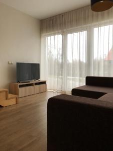 a living room with two beds and a flat screen tv at Ring Stop Holiday Apartment 11 in Sigulda