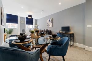 a dining room with a table and blue chairs at WhiskAwayStays - Victoria House - Apartment 3 in Worcester