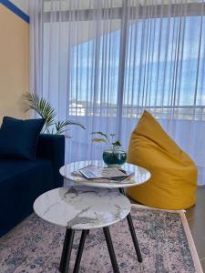 sala de estar con mesa y sofá amarillo en Gibel Apartments, en Golem