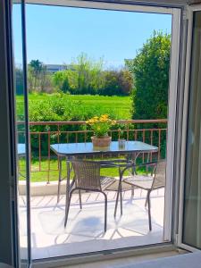 a patio with a table and chairs on a balcony at Lovely apartment by the sea 2 ….. in Epanomi