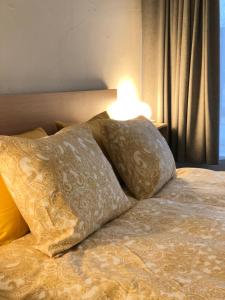 a bed with two pillows and a lamp on it at Ring Stop Holiday Apartment 11 in Sigulda