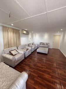 uma sala de estar com sofás de couro e pisos de madeira em Two rooms and one living room in Delma island em Da‘sah