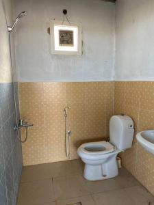 y baño con aseo y lavamanos. en Two rooms and one living room in Delma island, en Da‘sah