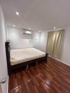 Cama en habitación con suelo de madera en Two rooms and one living room in Delma island, en Da‘sah