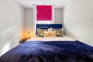a bedroom with a large bed with a red window at WhiskAwayStays - Victoria House - Apartment 3 in Worcester