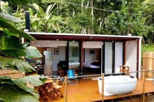 uma pequena casa com uma banheira num deque em Cabana do Araujo em Paraty