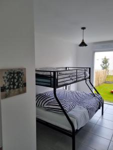 a bunk bed in a room with a window at Charmante maison entre mer et forêt in Saint-Jean-de-Monts