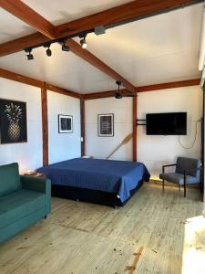 um quarto com uma cama, uma televisão e um sofá em Cabana do Araujo em Paraty
