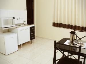 a small kitchen with a table and a microwave at Residence Barueri in Barueri