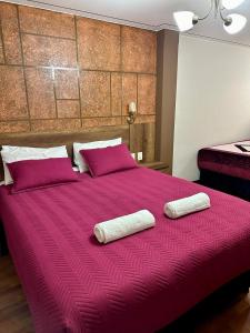 a large red bed with two white towels on it at Hotel Esmeralda in La Paz