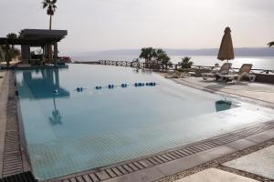 une grande piscine avec vue sur l'océan dans l'établissement O Beach Hotel & Resort, à Sowayma