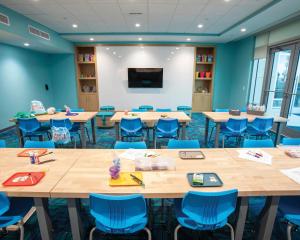 a classroom with wooden tables and blue chairs at Holiday Inn Club Vacations Myrtle Beach Oceanfront, an IHG Hotel in Myrtle Beach