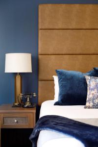 a bedroom with a bed with a wooden headboard and a lamp at Hotel at Old Town in Wichita