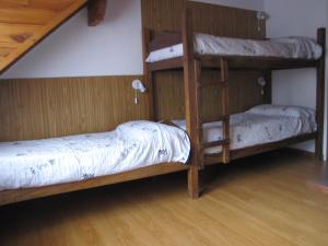 2 łóżka piętrowe w pokoju z drewnianą podłogą w obiekcie casas de alquiler Del Encuentro w mieście San Martín de los Andes