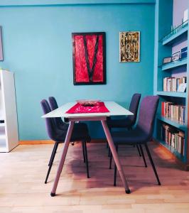 a table and chairs in a room with a book shelf at Euforbia House in Lido di Ostia
