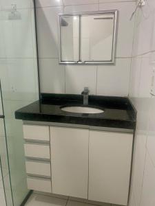 La salle de bains est pourvue d'un lavabo et d'un miroir. dans l'établissement Casa Maria Toda Linda N 53, à Belém