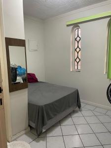 1 dormitorio con cama, ventana y espejo en Casa Maria Toda Linda N 53, en Belém