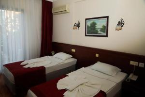 a hotel room with two beds and a window at EMBASSY Hotel in Antalya