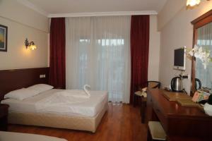 a hotel room with a bed and a desk and a computer at EMBASSY Hotel in Antalya