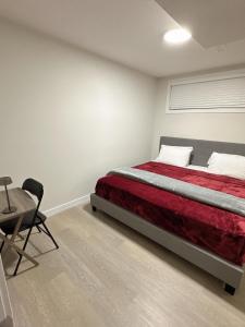 1 dormitorio con 1 cama, 1 silla y 1 mesa en Open modern concept 2BR basement, en Calgary