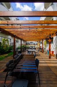 a wooden pergola with benches and tables on a deck at San Diego SUITES in Belo Horizonte