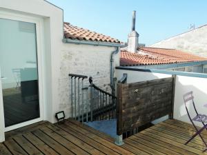 balcón de una casa con terraza de madera en Le Petit Cosy - terrasse privée, en Lagord