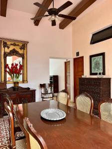 Hotel & Hostal Boutique Casa Garza في ميريدا: غرفة طعام مع طاولة ومروحة سقف