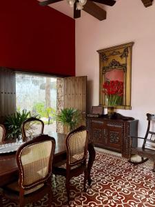 comedor con mesa, sillas y espejo en Hotel & Hostal Boutique Casa Garza en Mérida