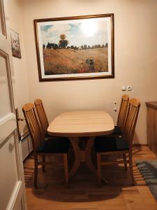 ein Esstisch mit Stühlen und ein Gemälde an der Wand in der Unterkunft Quiet Central in Ljubljana
