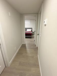 pasillo que conduce a un dormitorio con cama en Open modern concept 2BR basement, en Calgary