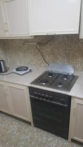 uma cozinha com um fogão preto numa cozinha em M apartment em Kuwait