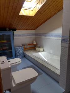 a bathroom with a toilet and a bath tub at Chalet con vistas al mar en la playa de A Lanzada in O Grove