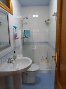 a white bathroom with a sink and a toilet at Chalet con vistas al mar en la playa de A Lanzada in O Grove