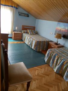 a hotel room with two beds and a window at Chalet con vistas al mar en la playa de A Lanzada in O Grove
