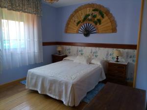 a bedroom with a white bed and a window at Chalet con vistas al mar en la playa de A Lanzada in O Grove