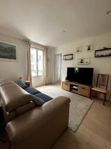 een woonkamer met een bank en een flatscreen-tv bij Un parfait chez soi à Puteaux in Puteaux