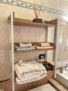 baño con estanterías con toallas y lavamanos en La casa di Maryangel en Medicina