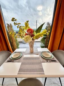 a table with a vase of flowers on a balcony at PENTHOUSE EXCLUSIVE VIEW , Iasi in Iaşi +83 photos