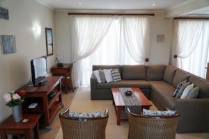 un soggiorno con divano e tavolo di Pinnacle Point Golf Estate Lodge 78 a Mossel Bay
