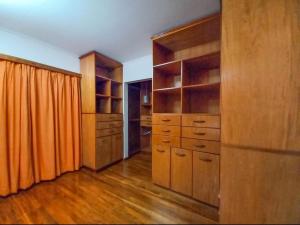 a large kitchen with wooden cabinets and an orange curtain at Blue Apart 2 in Puerto Rico
