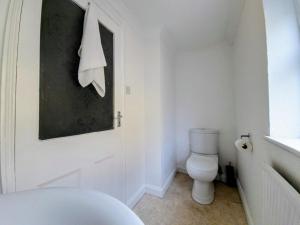 ein weißes Bad mit einem WC und einem Fenster in der Unterkunft Spacious 4 bedroom house in Brighton & Hove