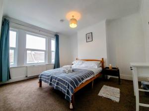 ein Schlafzimmer mit einem Bett mit einem Teddybär drauf in der Unterkunft Spacious 4 bedroom house in Brighton & Hove