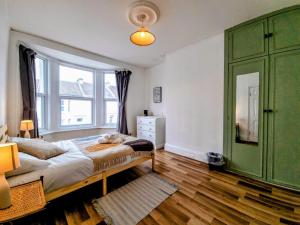 ein Schlafzimmer mit einem grünen Schrank und einem großen Fenster in der Unterkunft Spacious 4 bedroom house in Brighton & Hove