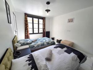a bedroom with two beds and a couch at Hypercentre Orléans Carmes in Orléans