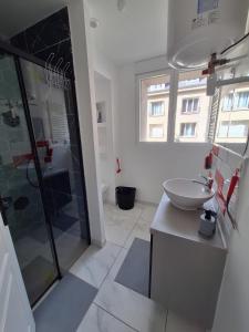a bathroom with a sink and a glass shower at Hypercentre Orléans Carmes in Orléans +20 photos