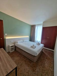 a bedroom with a bed and a table in it at Hostal Rugaca in Huesca +40 photos