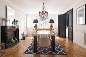 une salle à manger avec une table et un lustre dans l'établissement 205sm luxury and design flat at Paris Montmartre, à Paris