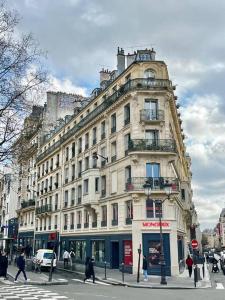 - un grand bâtiment dans une rue de la ville où les gens traversent la rue dans l'établissement 205sm luxury and design flat at Paris Montmartre, à Paris